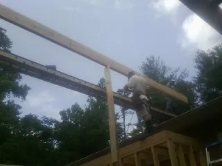 Carpenter setting a ridge beam over a new addition frame — Ice Dam Removal by Roofing Brothers in Arvada
