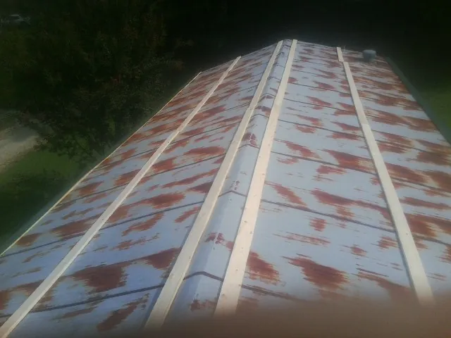 Rusted metal roof panels with new wood purlins before replacement — Storm Damage Roof Repair in Arvada by Roofing Brothers