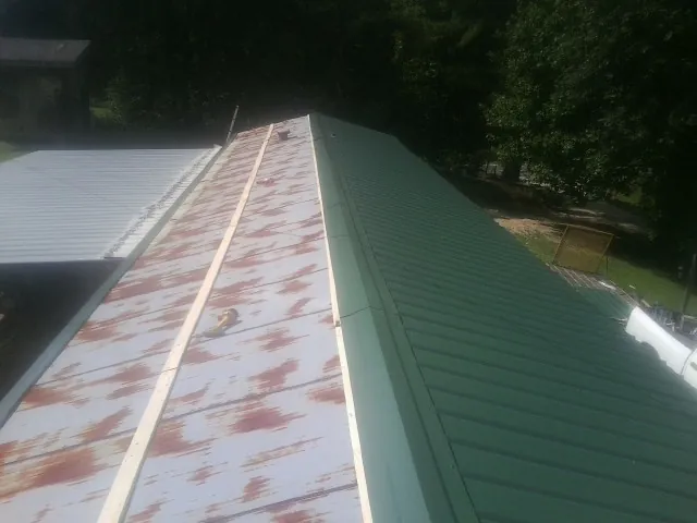 Old rusted panels beside newly installed green metal roofing — Wind Damage Roof Repair by Roofing Brothers in Arvada