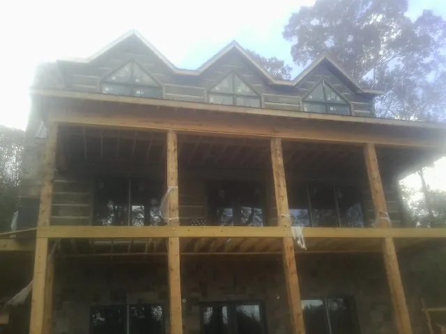 Dormers and porch framing on a large log home under construction — Roof Coating work by our crew in Arvada