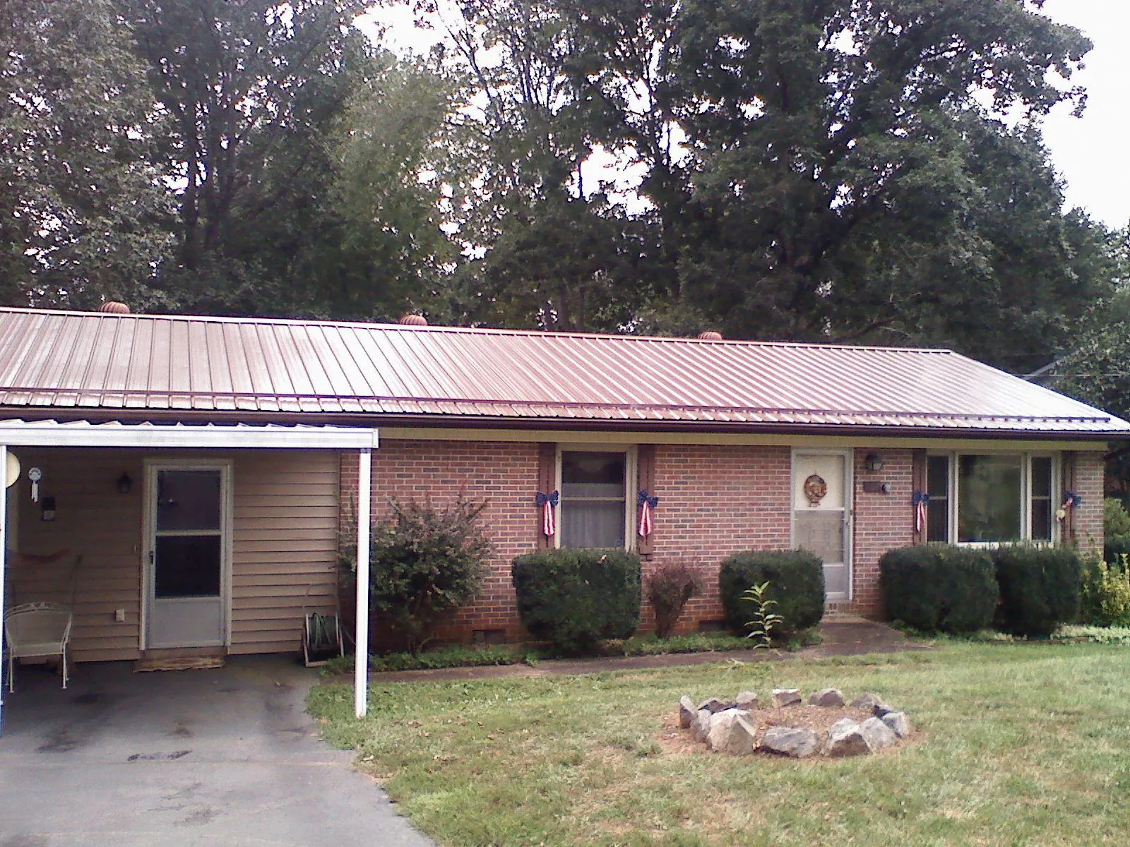Bronze metal roof and carport on a brick ranch home — Roof Repair work by our crew in Arvada